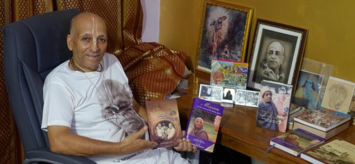F-Riddha-Das-at-his-writing-desk-holding-copies-of-his-published-works-documenting-the-early-years-of-ISKCON-in-South-Africa_